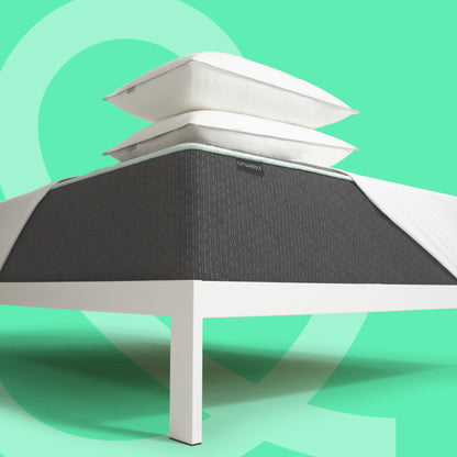 Tuft and Needle Mint mattress II with pillows and a mattress protector stacked.