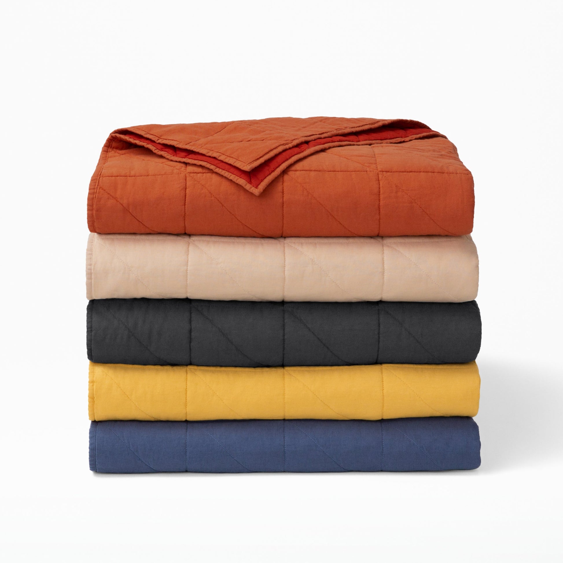 The Tuft and Needle Quilt folded and stacked||color:chai